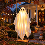 GlowSwing ghost hanging from a front-yard tree branch over the path at night